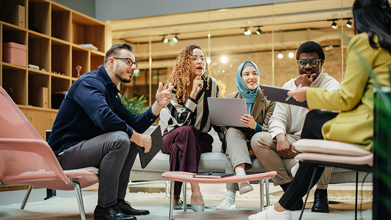 Wide Shot of a Multiethnic Group of People Discussing Ideas in a Meeting Room at Office