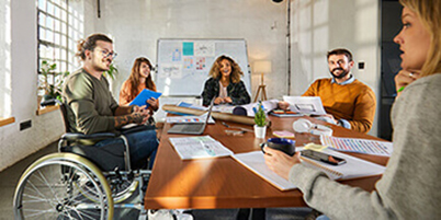 Happy businessman in a wheelchair having a meeting with his colleagues