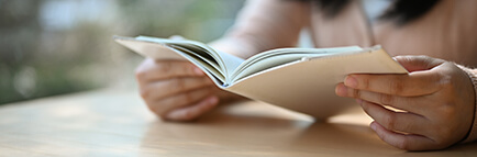 Woman sitting at a table and reading a booklet