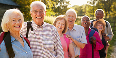 Smiling and laughing group of senior persons outside.