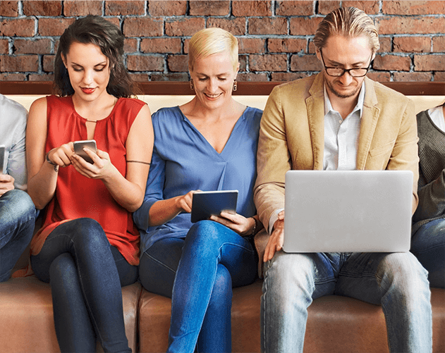 Multiple people seated on a bench reading a blog on various devices